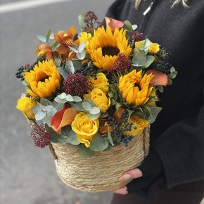 Композиция в сумке "Тональность" из подсолнухов, калл, ягод вибирнума, лимонных роз, скиммии и орхидеи в Краснозаводске